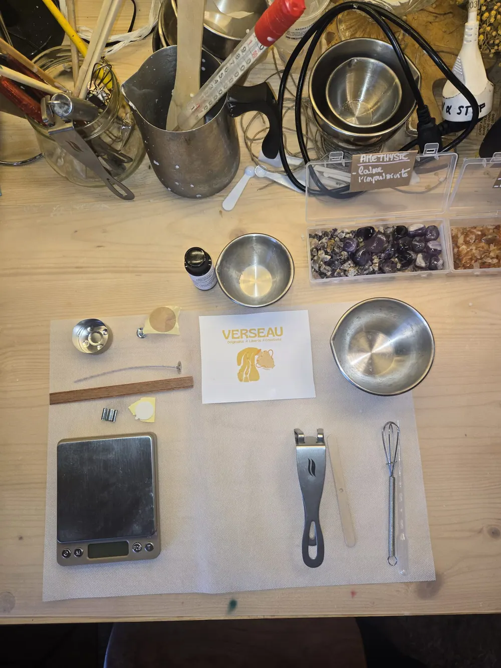 La place dressée pour l'atelier duo : la carte du signe Verseau, la balance, les mèches et les pigments.